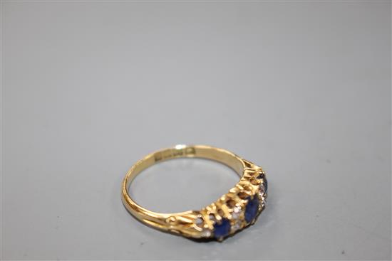 A George V 18ct gold, three stone sapphire and six stone diamond set half hoop ring,